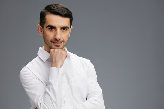 man in a white shirt a pensive look Gray background
