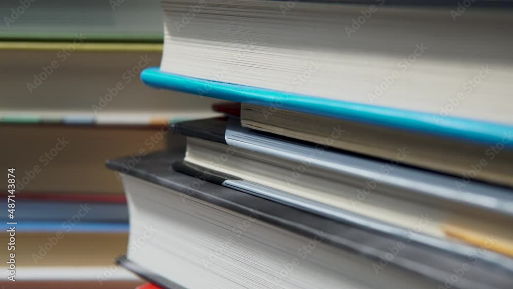 Poster close up view of stacked books - shallow depth soft focus pan shot