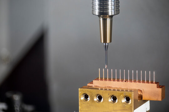 Closeup scene the CNC milling machine cutting the  copper electrode parts with solid ball end mill tools.