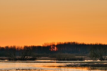 The sun over the river is reflected in the water