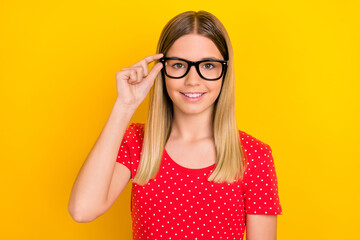 Photo of young pretty smart girl hand touch eyeglasses ophthalmologist isolated over yellow color background