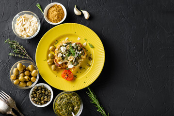 Baked cauliflower steak with chimichurri sauce, almond flakes, capers on a yellow plate. Vegetarian food. Alternative delicious food.