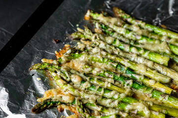 Asparagus baked with cheese on a baking sheet. Vegetarian food. Healthy food.