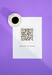 QR code for online menu service at table in restaurant. New contactless technology lifestyle protection coronavirus pandemic in restaurant. Flat lay, purple background