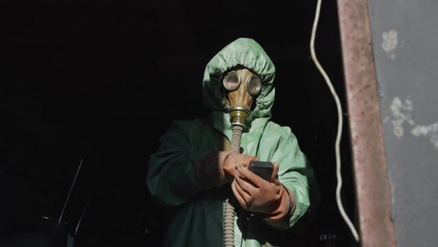 Person in protective costume have radiation control with Geiger counter. Biohazard and air pollution problem.