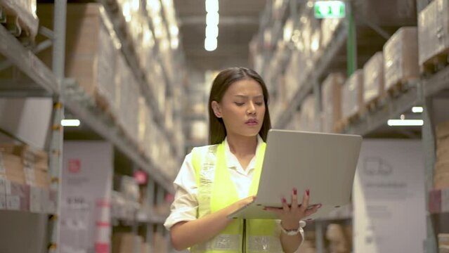 Asian woman warehouse worker doing stocktaking of products management in cardboard box on shelves but she forgot detail, feeling stressed, having to cover up a mess or mistake
