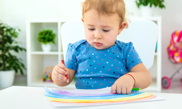 The child draws a rainbow. Selective focus.