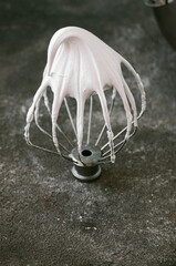 Whipped egg whites - beaten italian meringue on a wire whisk on gray background, copy space. - 487148692