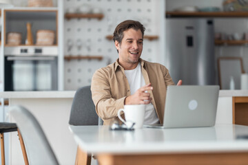 Obraz premium Happy male freelancer having a video call over laptop at home.