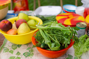 Fruits, vegetables and greens on the table in close-up. Summer vacation. Picnic in nature.
