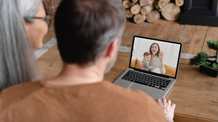 Senior old elderly grandparents grandfather and grandmother parents talking remotely on distance with daughter and grandson on video call conference conversation online on laptop screen.