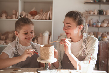 Mom and son having fun, learning pottery together at art studio
