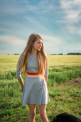 Portrait of a beautiful young girl in a summer field outside the city.