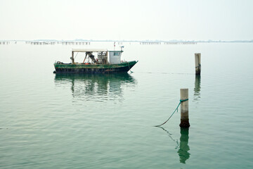Barca per raccolta mitili da allevamento ormeggiata nel mare piatto nei pressi di Chioggia Venezia Italia