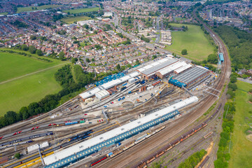 Aerial Photo of a train station works depot with lots of trains in the tracks located in the village of Halton Moor in Leeds, West Yorkshire in the UK on a bright sunny summers day.