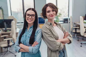 Photo of two intelligent ceo ladies cross arms stand back to back ready finance innovation project doing in modern workspace