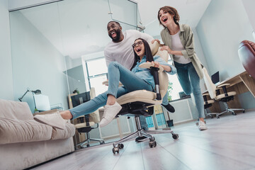 Full size photo low angle view of friends colleagues guy lady ride fast speed chair start-up relax in modern workspace