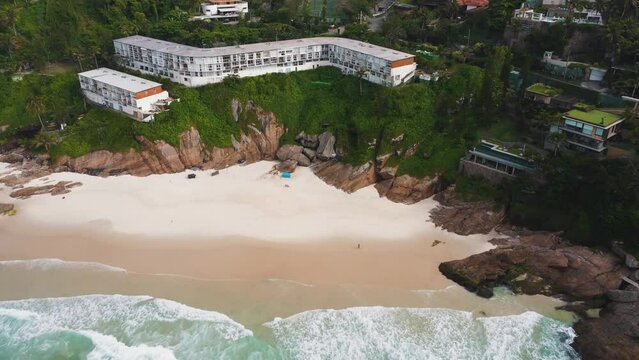 Aerial view of Praia da Joatinga, a paradise in Rio de Janeiro, Brazil. Sunny day with some clouds in the morning. Sea with good waves for surfers. Greenish sea. Drone take.