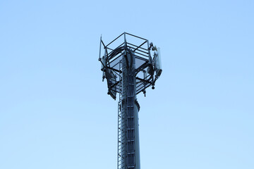 Telecommunication tower of 4G and 5G cellular. Macro Base Station. 5G radio network telecommunication equipment with radio modules and smart antennas mounted on a metal. Blue sky in the background.