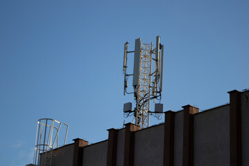 Telecommunication tower of 4G and 5G cellular. 5G radio network telecommunication equipment with radio modules and smart antennas mounted on a metal. Blue sky in the background. Located on the roof.