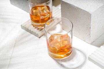 Alcoholic drink, cold summer hard strong alcohol cocktail, whiskey with ice in short glasses on white background