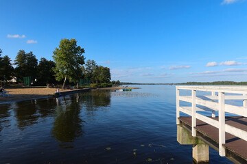 Narew river in Serock town, Mazovia, Poland. White pier at Narew river in Serock. Next to the beach.