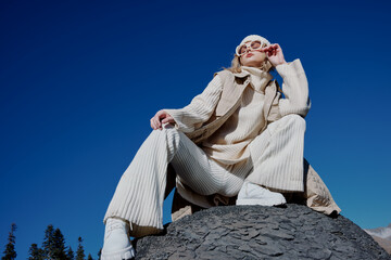 tourist in autumn clothes stands on a rock landscape blue sky lifestyle