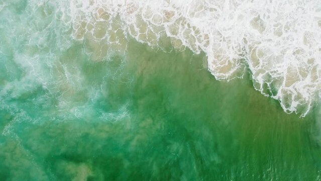 Aerial view of Praia da Joatinga, a paradise in Rio de Janeiro, Brazil. Sunny day with some clouds in the morning. Sea with good waves for surfers. Greenish sea. Drone take.