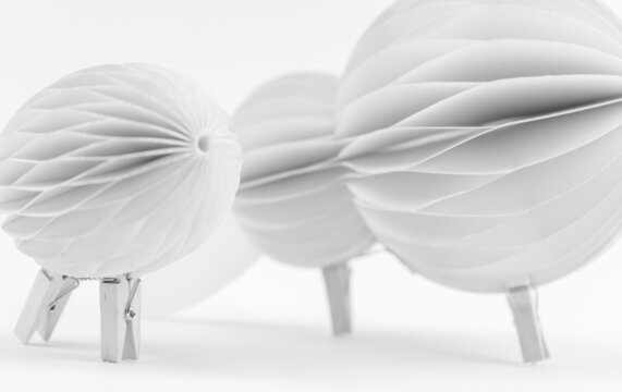 Papierowe kule z klamerkami, abstrakcyjny wz&oacute;r, białe tło.