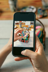 Hands with the phone close-up pictures of easter egg