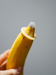 An unpacked condom perched on a banana.