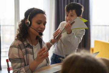 Woman having online job while helping her child with hometask