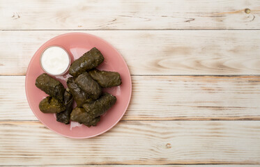 Delicious dolma served on wooden table background, top view