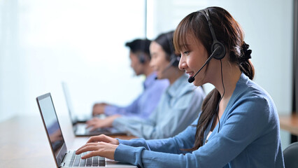 Asian call center and customer service using laptop computer and calls talk support to customers and wearing headset, Telemarketing, customer support agent provide service on telephone concept