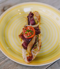 Canape hecho de pan con jamon iberico y verduras 