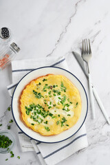 Omelette or frittatas with green onions or young greenery and mozzarella on white marble table background. Healthy food concept. Breakfast. Copy space. Top view. Mock up.