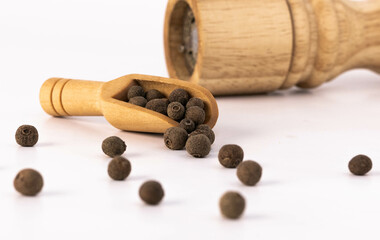 Black pepper. Wood spoon. Pepper mill. Light wooden pepper mill isolated on white background. Black...