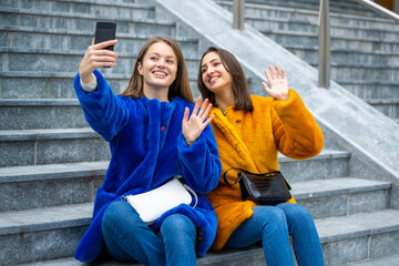 two generation z girls taking selfie, friends making video call outdoor, generation z concept
