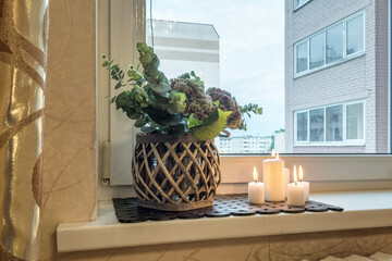 vase with flowers on windowsill in old vintage style with fruits or candles