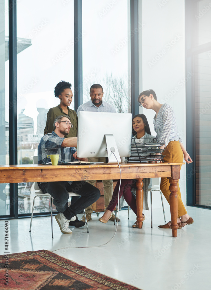 Poster working together to get the task done. shot of businesspeople working together in the office.