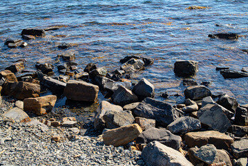 Beautiful ripples on river flow over stones. Natural stones in water. Selective focus on object