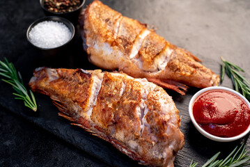 grilled red sea bass with rosemary and spices on a stone background 