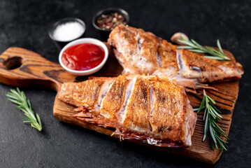grilled red sea bass with rosemary and spices on a stone background 