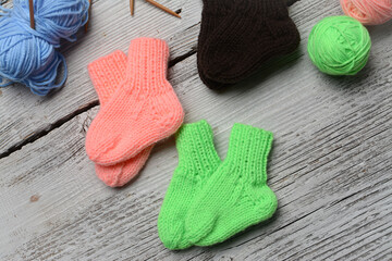 Messy knitters table, yarn and small baby socks on it