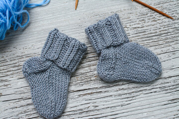 Messy knitters table, yarn and small baby socks on it