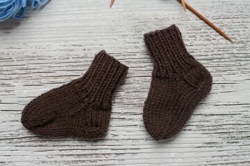 Messy knitters table, yarn and small baby socks on it