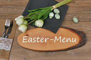 Easter table setting with tulips, easter eggs, cutlery and the text Easter menu.