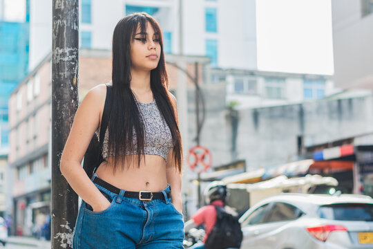 beautiful latina girl with brown skin standing on the street in the city of Pereira-Colombia. young university student thinking about her life project while waiting for the bus.