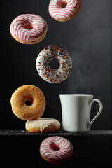 Sweet tasty donuts and a white mug with hot drink.