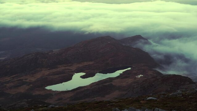 Dawn mountain timelapse with yellow murky clouds rolling over the terrain